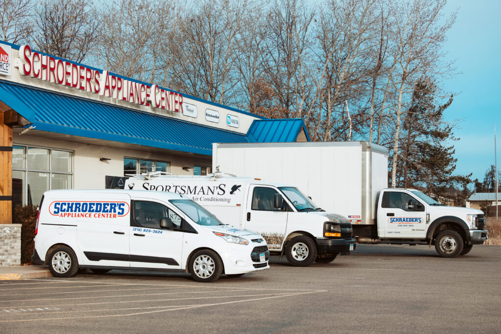 Various Schroeder's trucks in front of the Schroeders Appliance Center